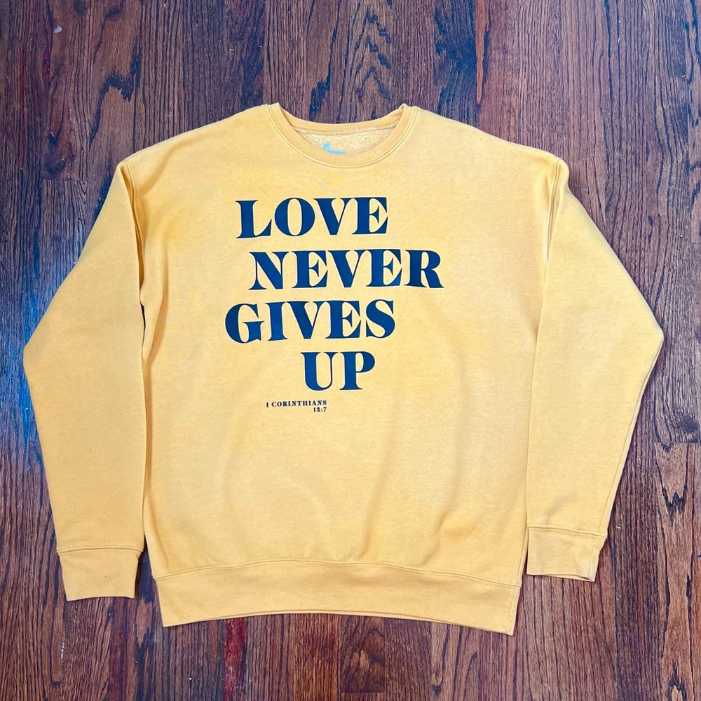 Love Never Gives Up Yellow Crewneck Sweatshirt | 1 Corinthians 13:7 Womens Med